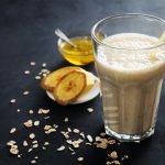 A glass of milk with a spoon next to it