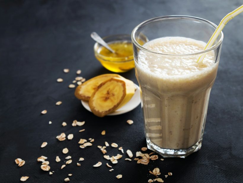 A glass of milk with a spoon next to it