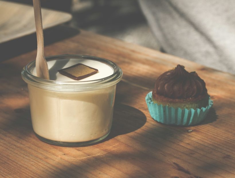 a cupcake and a glass of milk on a table