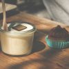 a cupcake and a glass of milk on a table