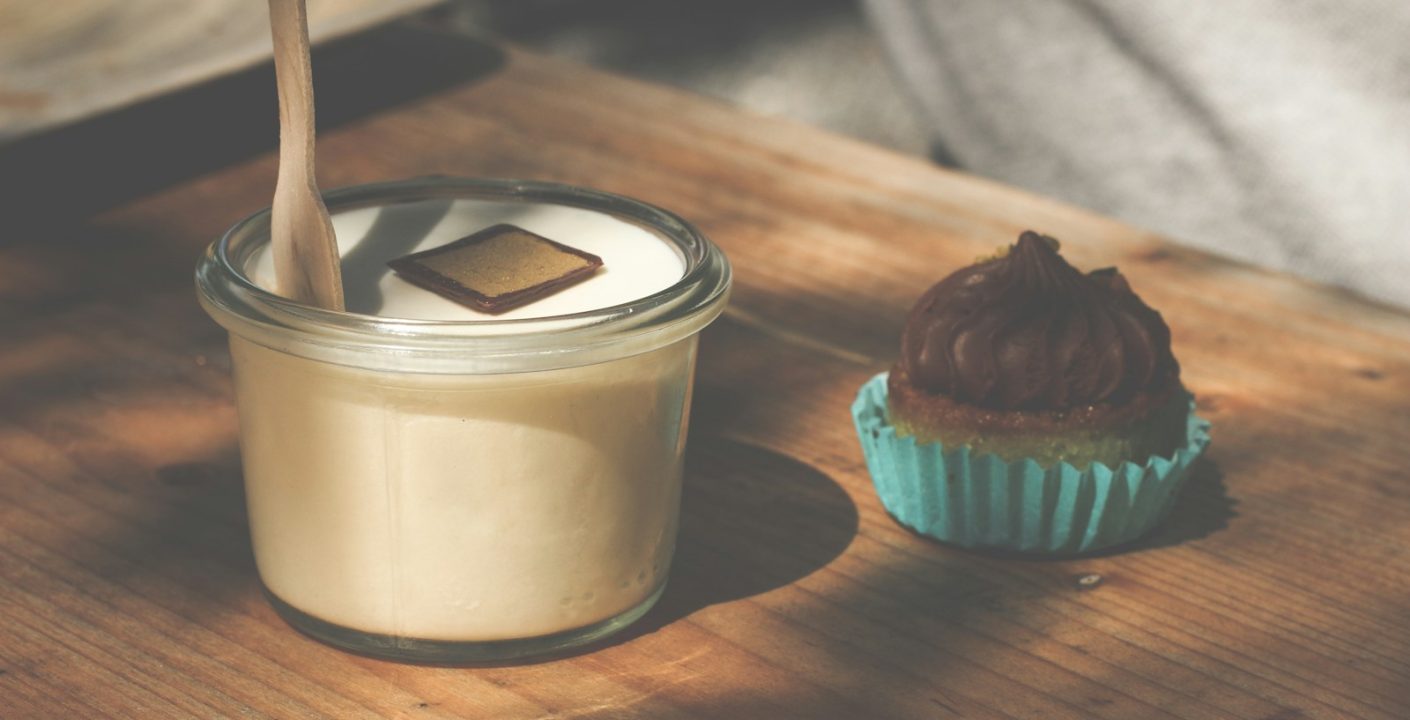 a cupcake and a glass of milk on a table